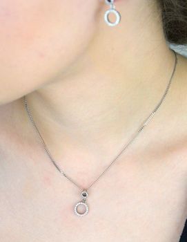 Stylowa srebrna zawieszka próby 925 z dwoma połączonymi kółeczkami, ozdobiona lśniącymi cyrkoniami. Symboliczna forma i elegancki blask – idealna na prezent lub do codziennych stylizacji. delikatny blask  W 2231  (2).JPG